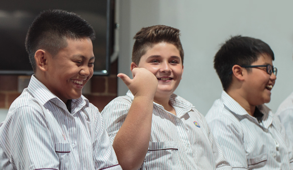 Group of three young students happily laughing.