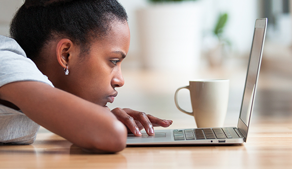 A young woman in deep focus on her laptop.