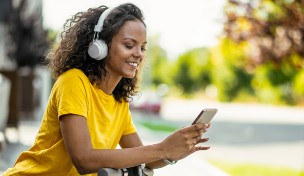 Young woman enjoying her mobile phone outdoors.