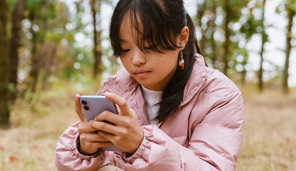 A young woman in deep focus on her mobile phone